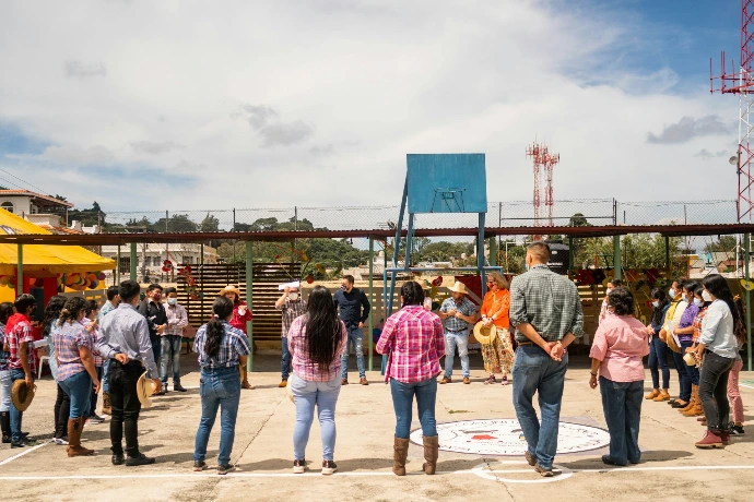 A group of people standing around a basketball court